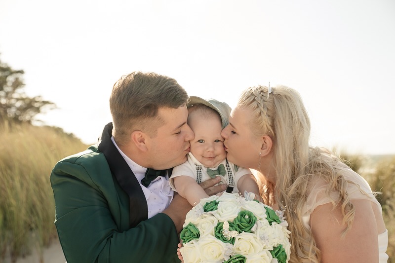 Brautpaar gibt kleinem Sohn einen Kuss auf die Wange fotografiert von Fotografin Anett Petrich